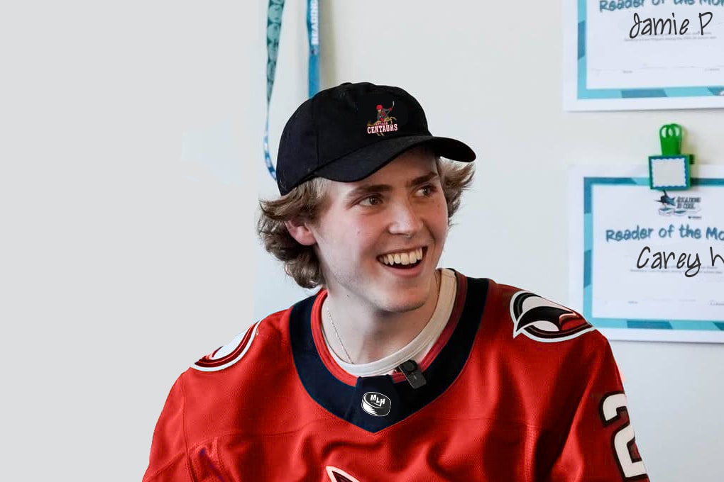LaPointe, in a red jersey and Centaurs’ cap, in front of some children’s reading certificates