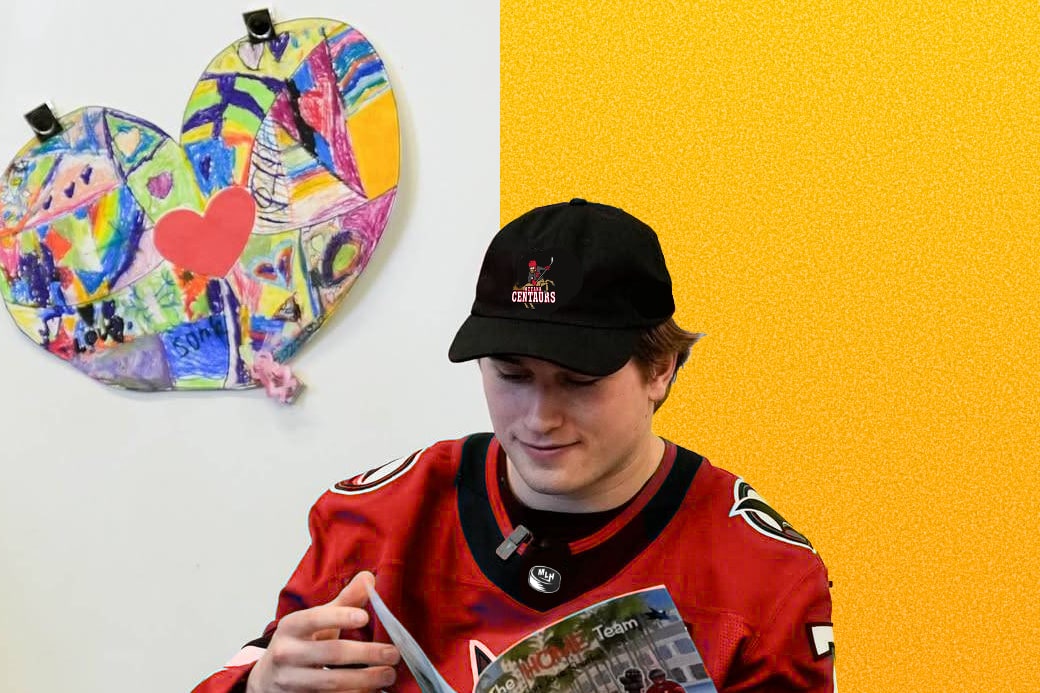 Luca Haas, in a red jersey and Centaurs’ cap, with a children’s book in hid lap
